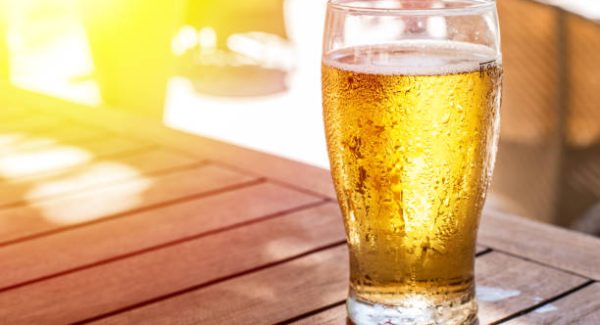 Glass of light beer on the wooden table.